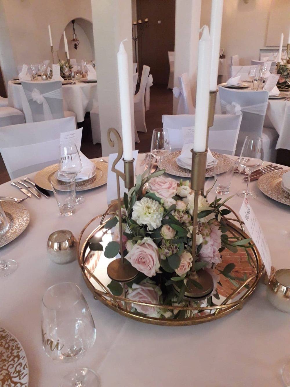 Festlich gedeckter Hochzeitstisch mit Blumengesteck und Kerzen