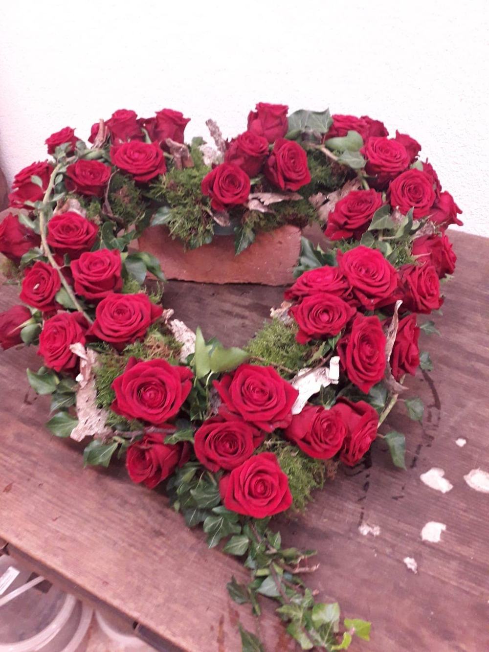Herz aus roten Rosen und Efeu